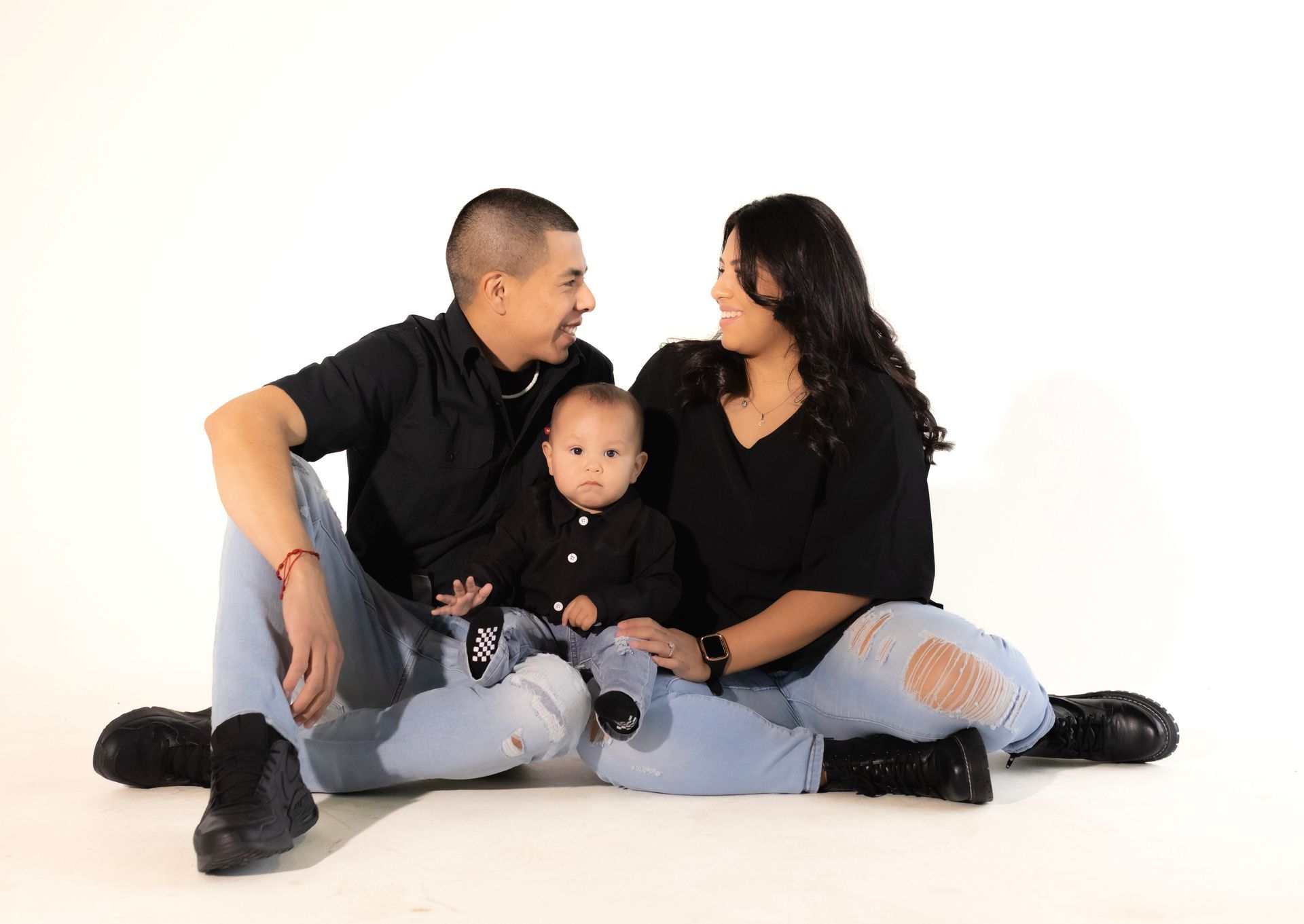 A family is sitting on the floor with a baby.