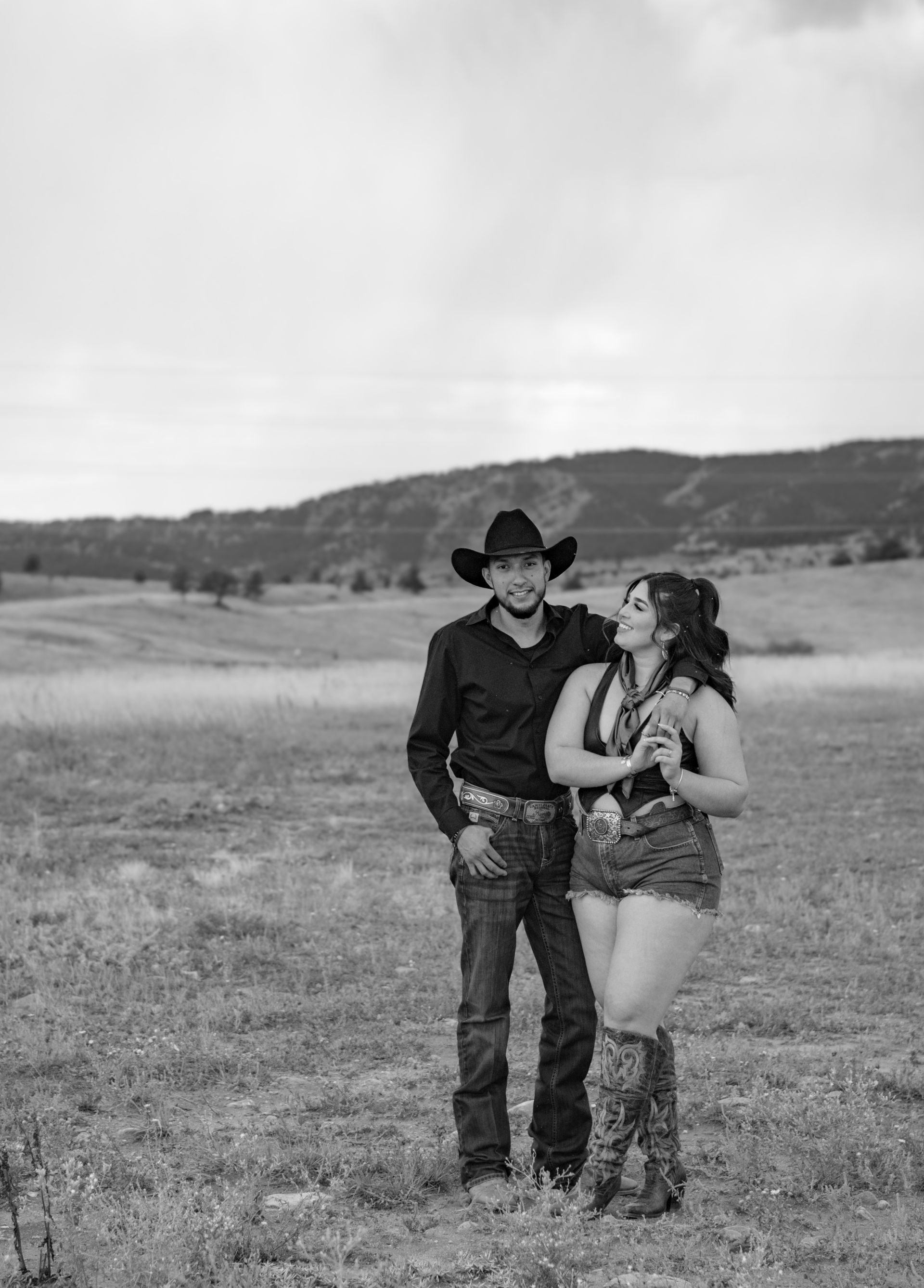 A black and white photo of a man and a woman standing in a field.