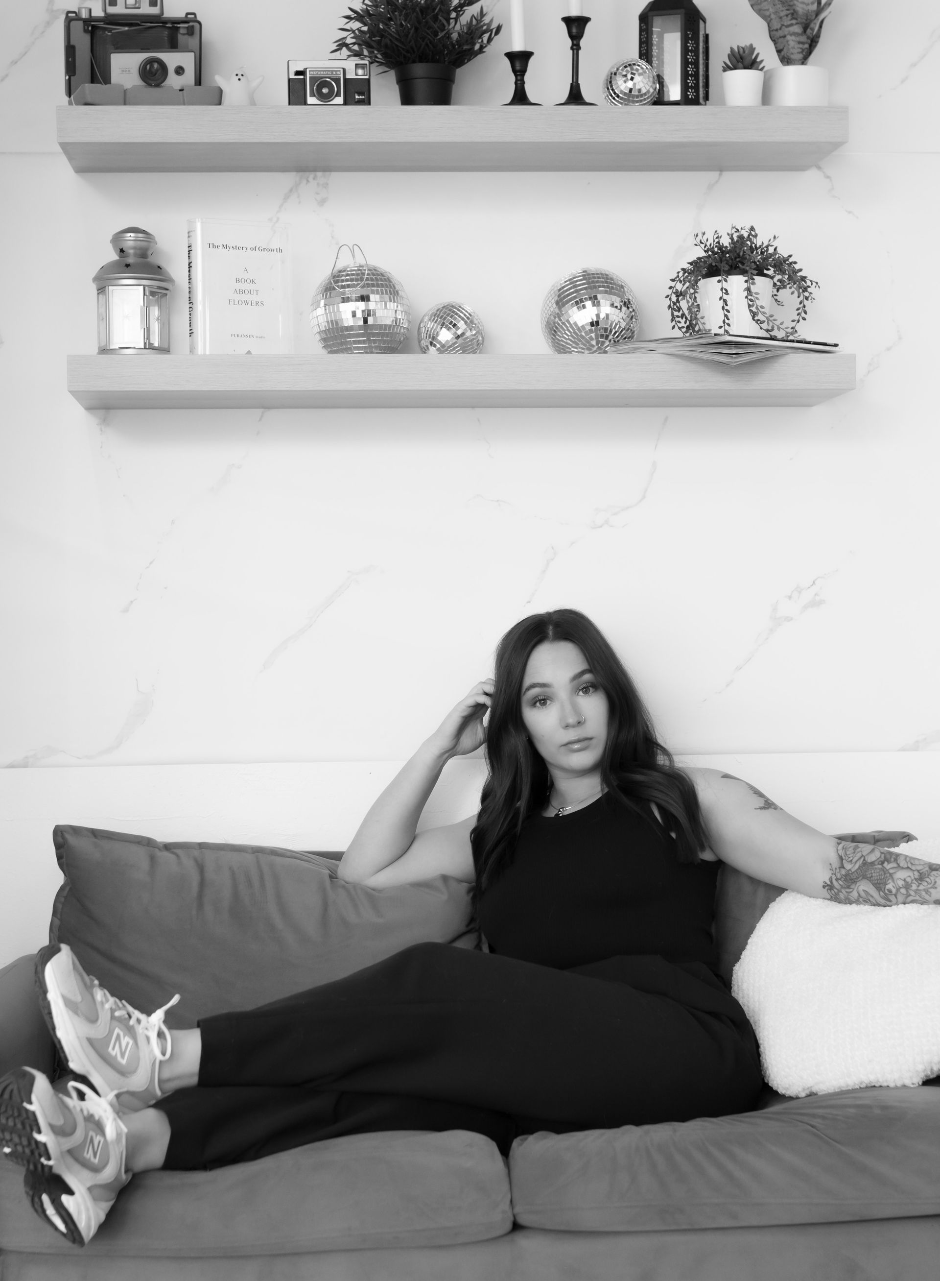 A black and white photo of a woman sitting on a couch