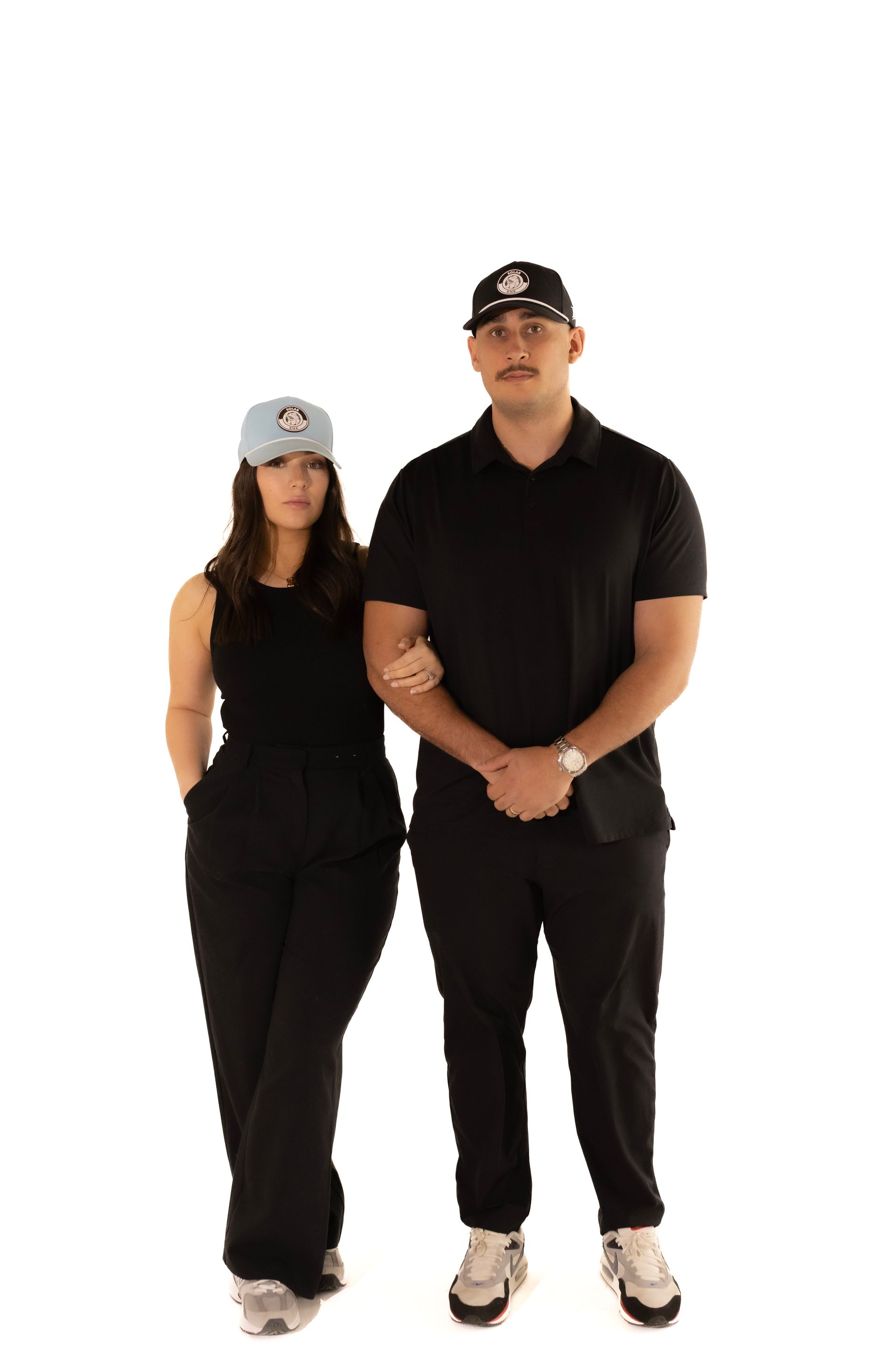 A man and a woman are standing next to each other on a white background.