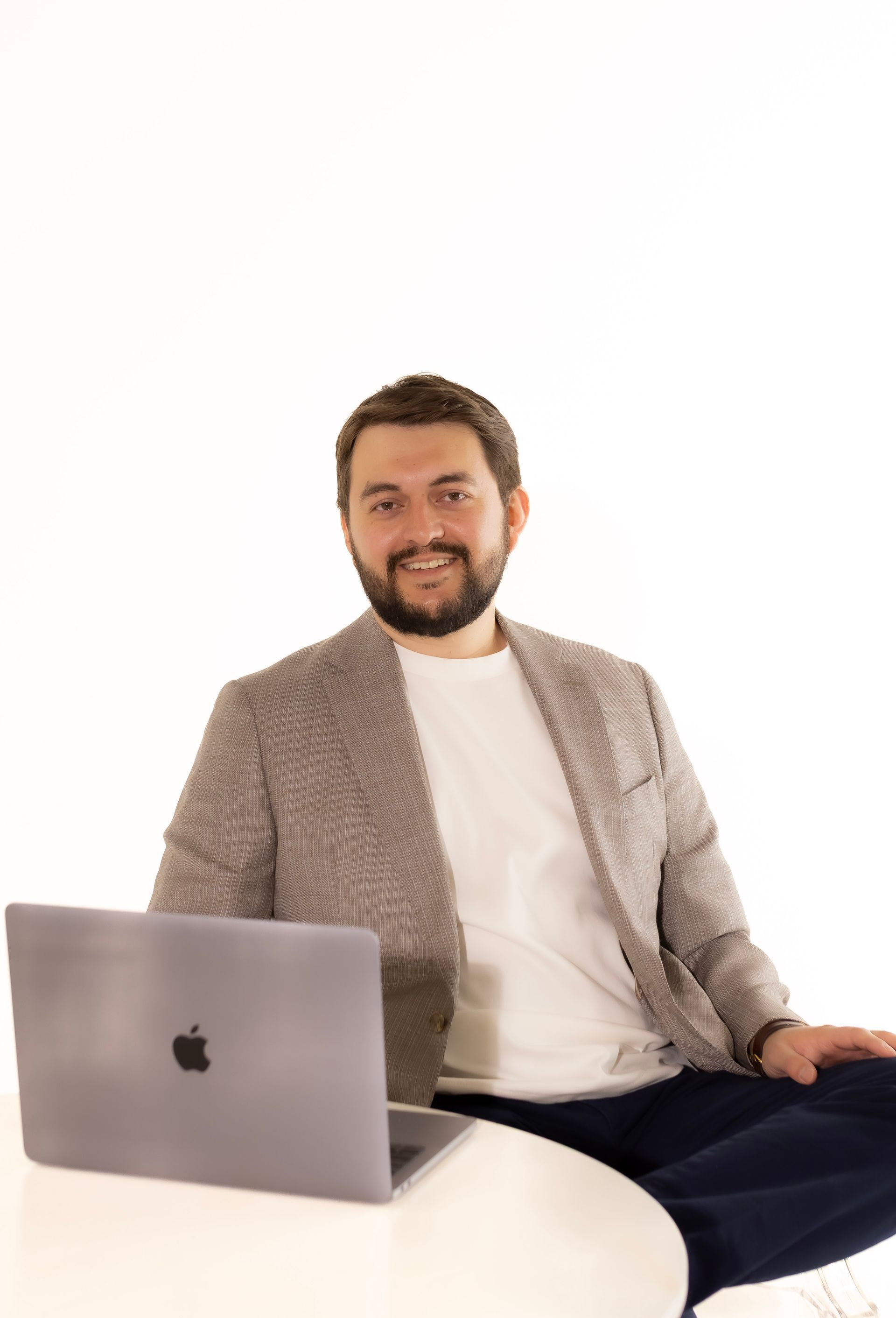 A man is sitting at a table with a laptop on it.