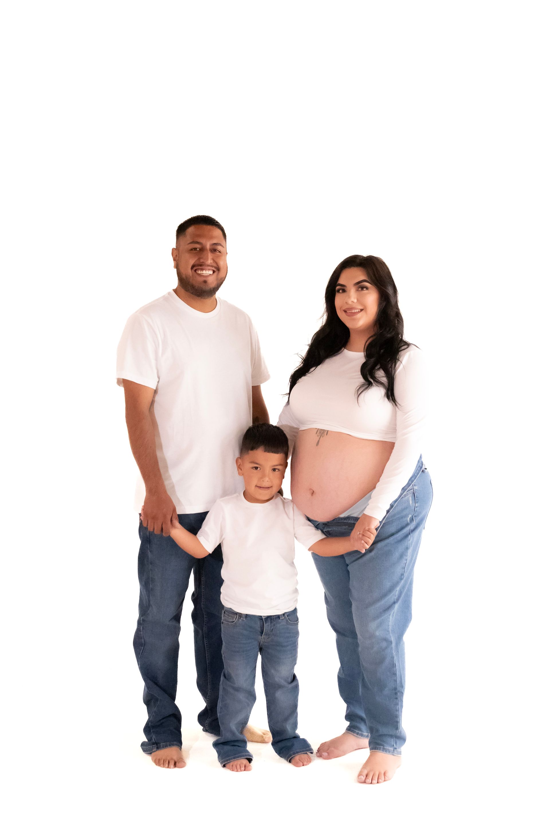 A pregnant woman , a man and a boy are posing for a picture.