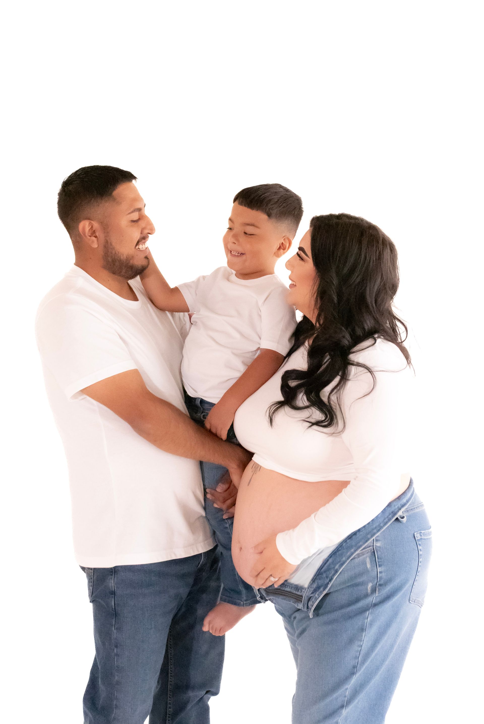 A pregnant woman is standing next to a man and a child.