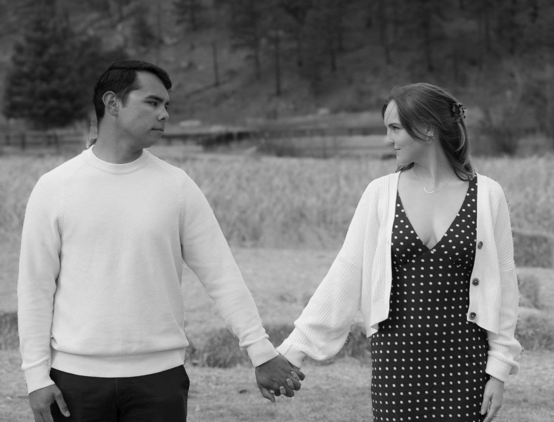 A man and a woman are holding hands in a field.