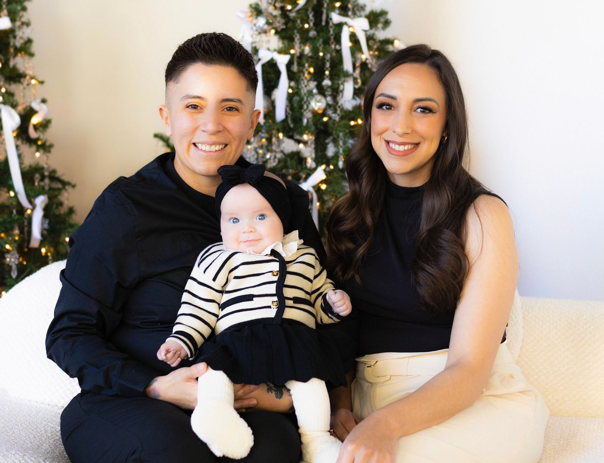 A family is posing for a picture in front of a christmas tree.