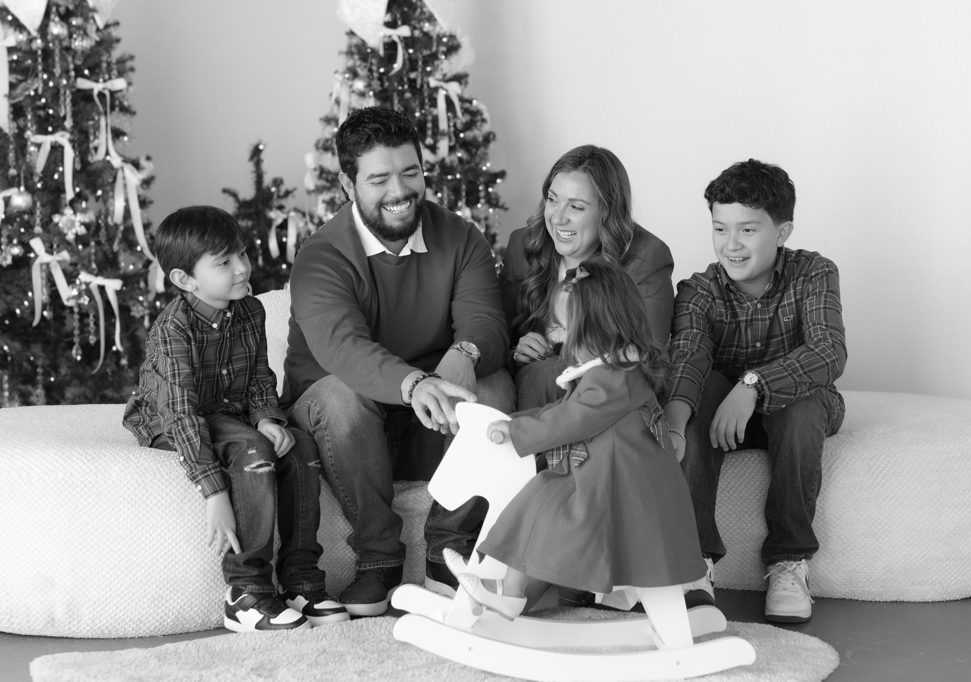 A family is posing for a picture in front of a christmas tree.