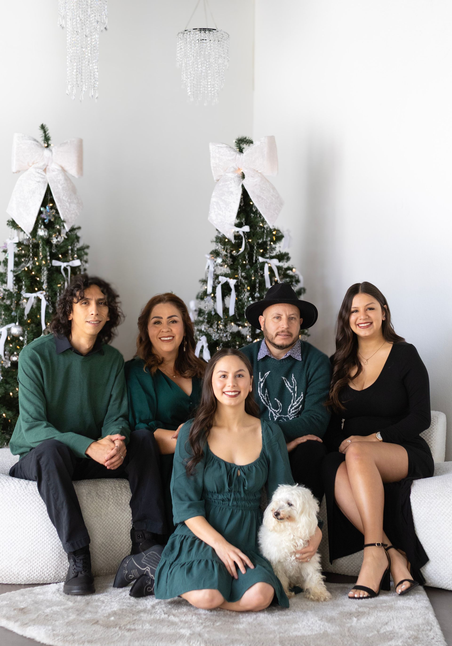 A family is posing for a picture in front of a christmas tree.
