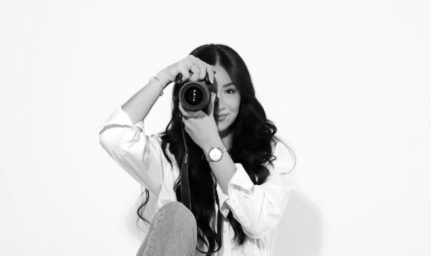 A woman is taking a picture of herself with a camera.