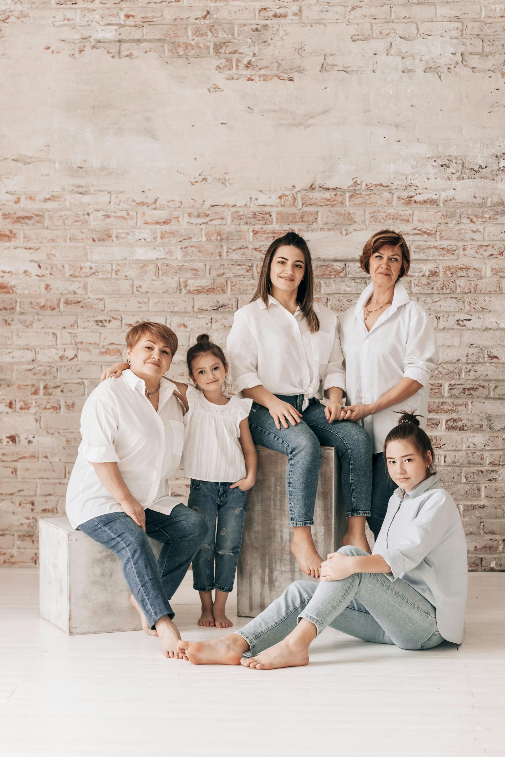 A group of women are posing for a picture in front of a brick wall.