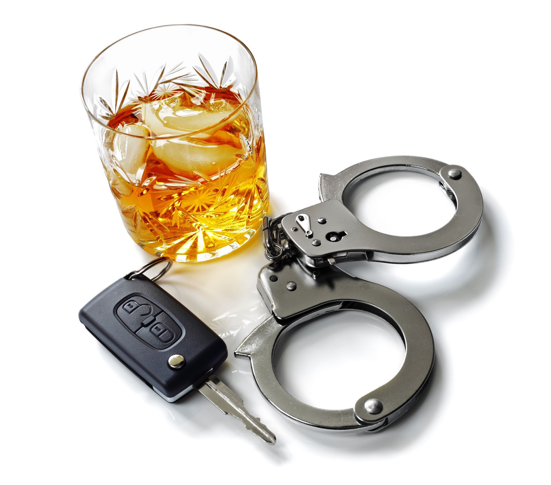 a pair of handcuffs next to a car key and a glass of alcohol
