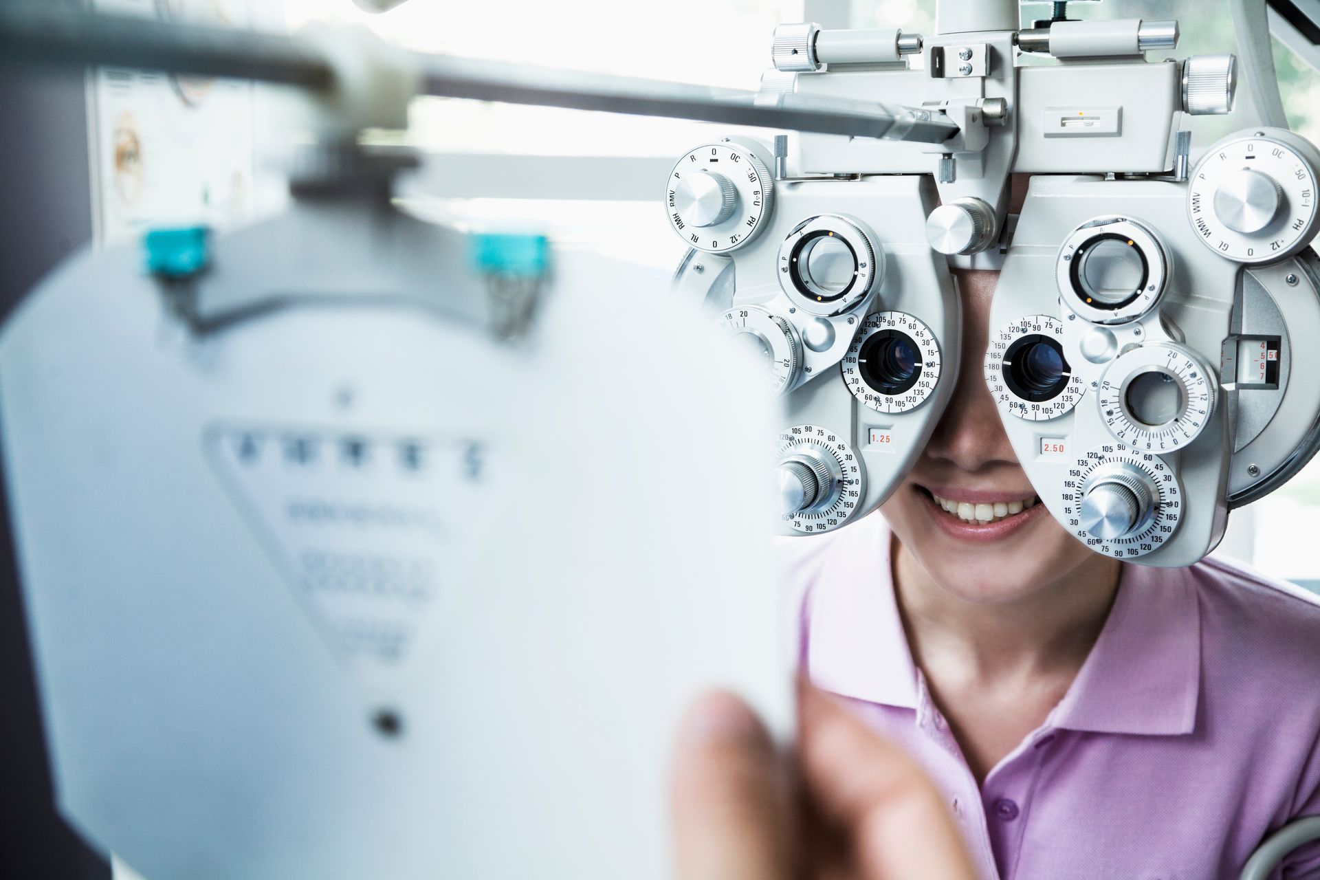 Close-up of an optometrist doing an eye exam on a young woman. 