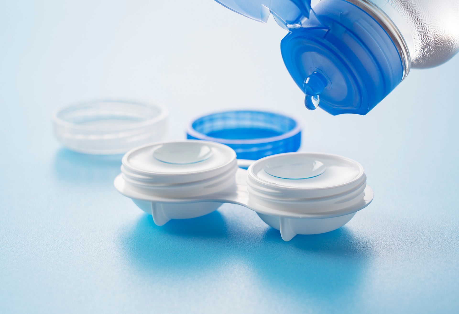 Contact lens case with lenses, being cleaned with solution, blue and white. Contact lens case with lenses, being cleaned with solution, blue and white.
