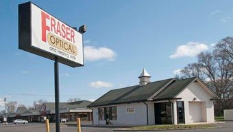 Fraser Optical and Hearing Aid building with sign in front of a blue sky.