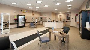 Interior of an optometrist's office with eyeglass displays, a front desk, and a waiting area.
