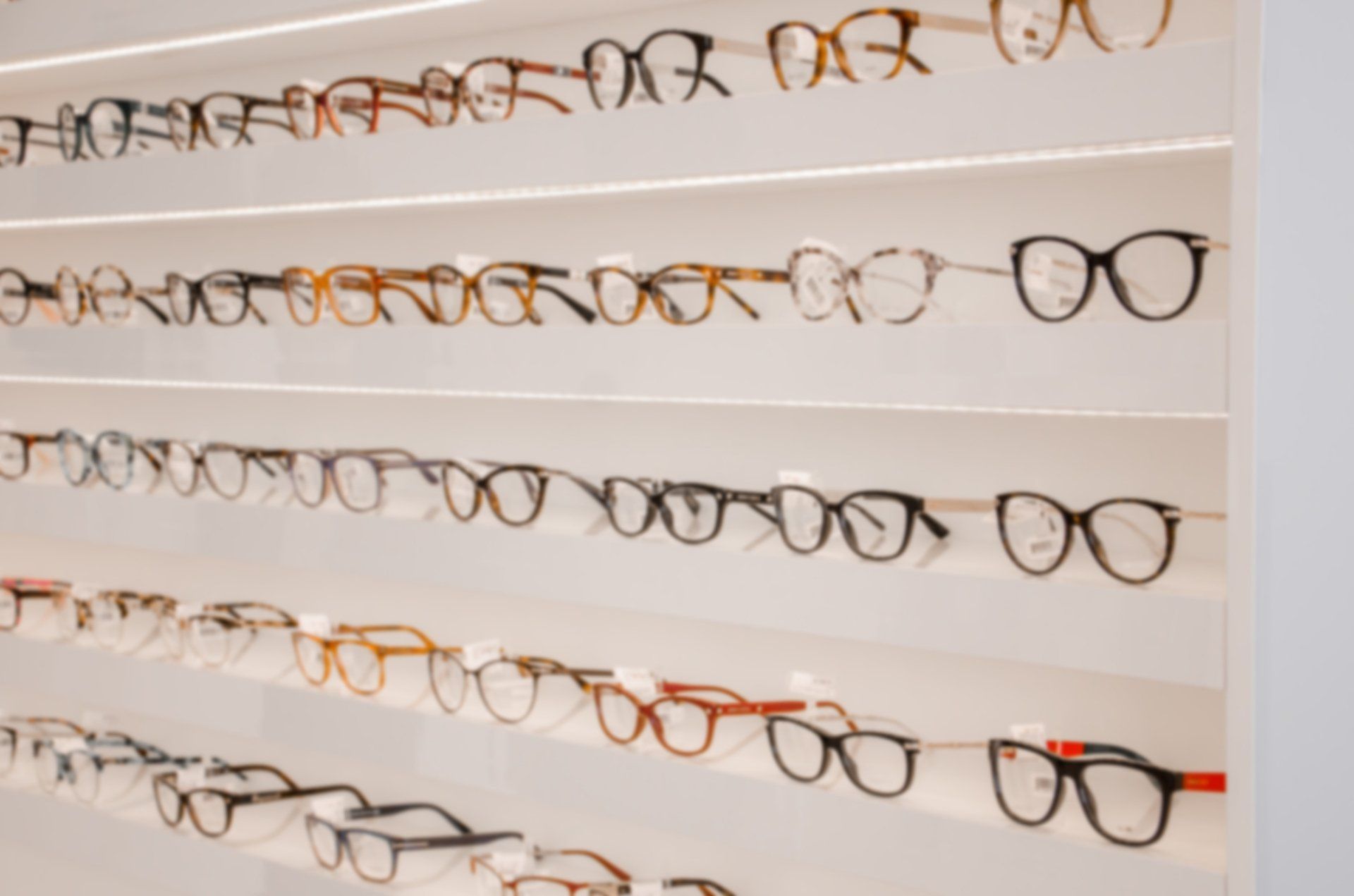 Eyeglasses displayed on shelves in a well-lit store, various frame styles and colors. Eyeglasses displayed on shelves in a well-lit store, various frame styles and colors.