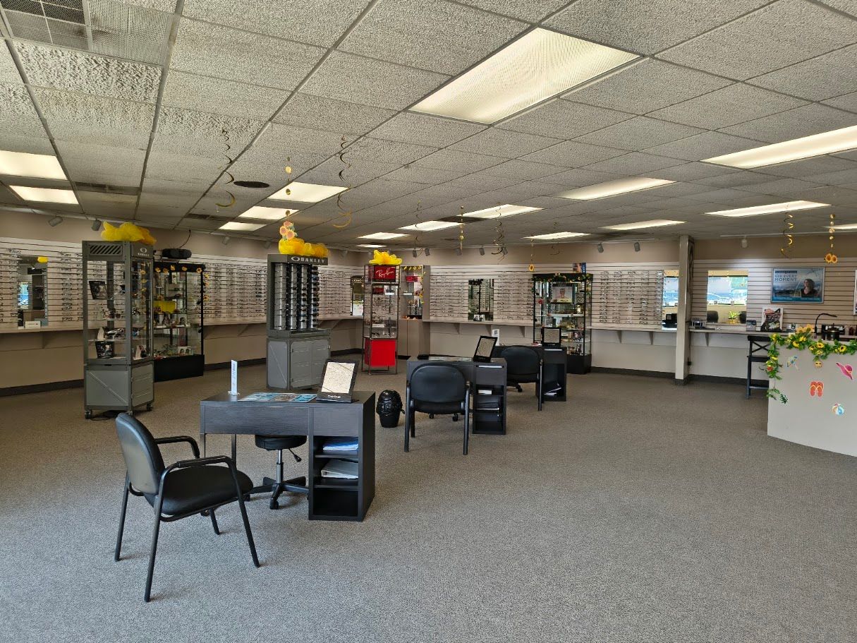 Office lobby with desks, chairs, and shelves under fluorescent ceiling lights