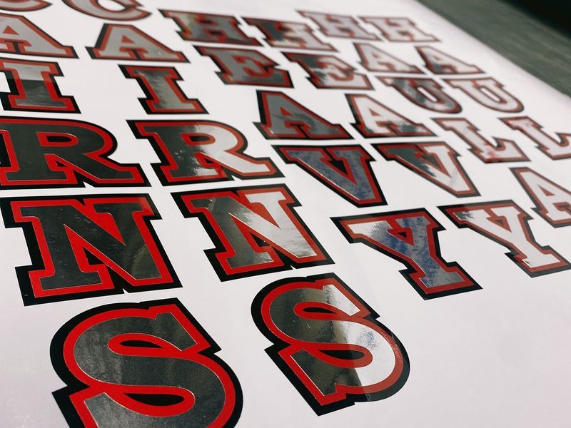 Letters With a Silver Middle, Black Outline, and Red Trim on a White Sheet — Millard Signs in Bungalow, QLD