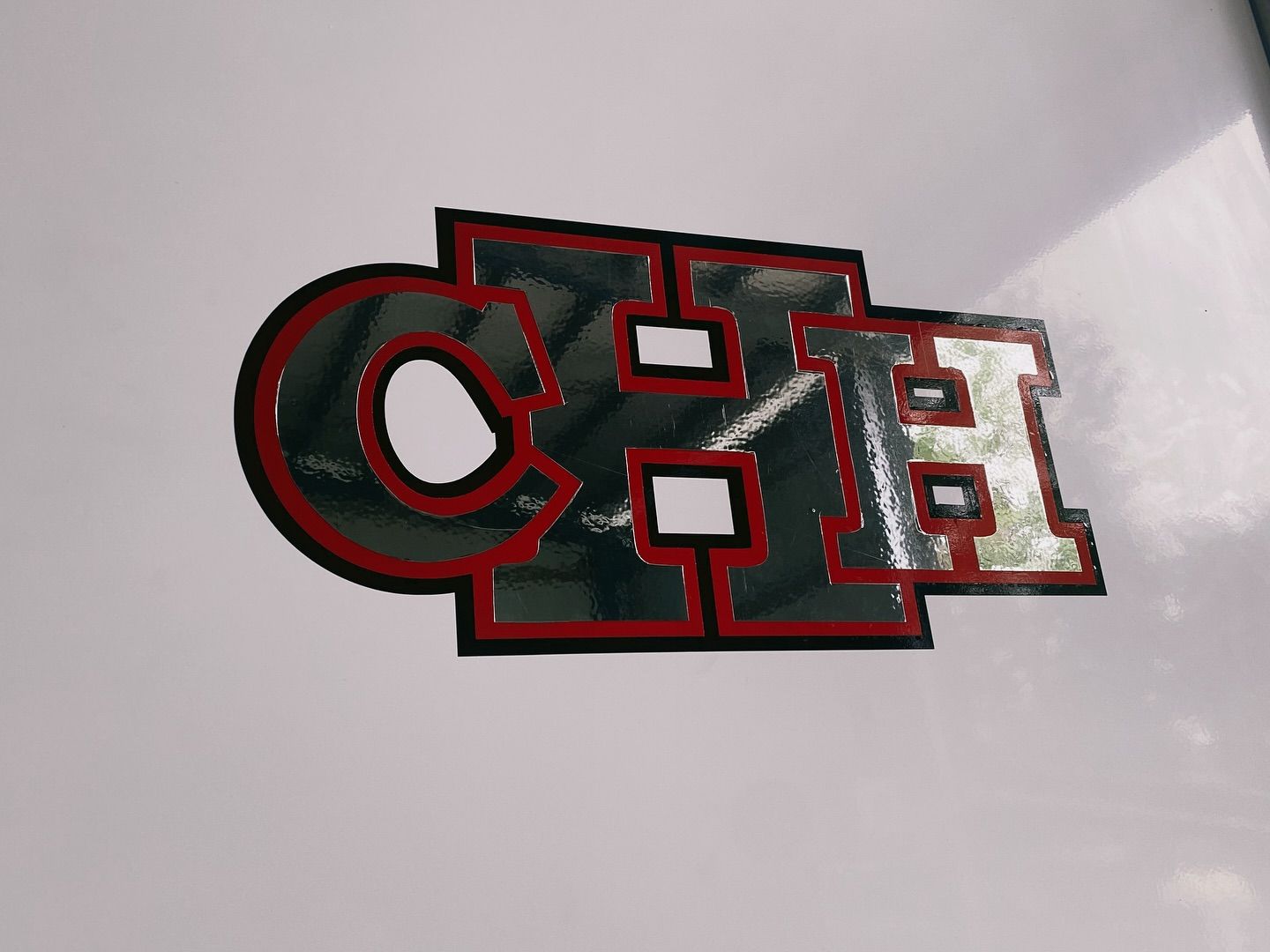 CH logo With Silver Letters, Red Borders, and Black Outline on a White Surface — Millard Signs in Portsmith, QLD