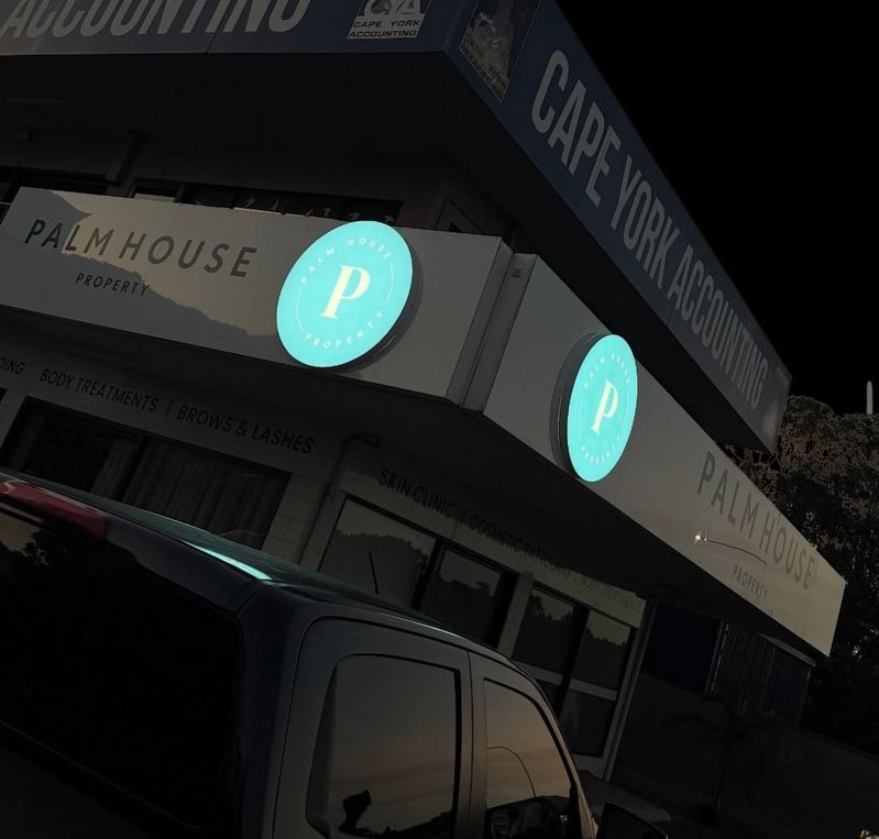 Palm House Properties Building With Teal Circular Signs — Millard Signs in Portsmith, QLD