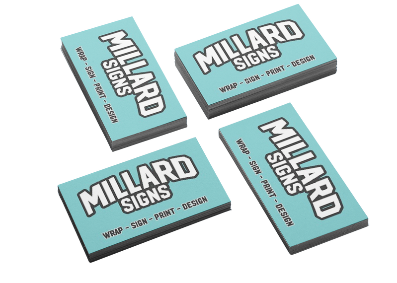 Woman Smiling While Holding a Card, Using a Laptop, at a Table in a Home Setting — Millard Signs in Bungalow, QLD