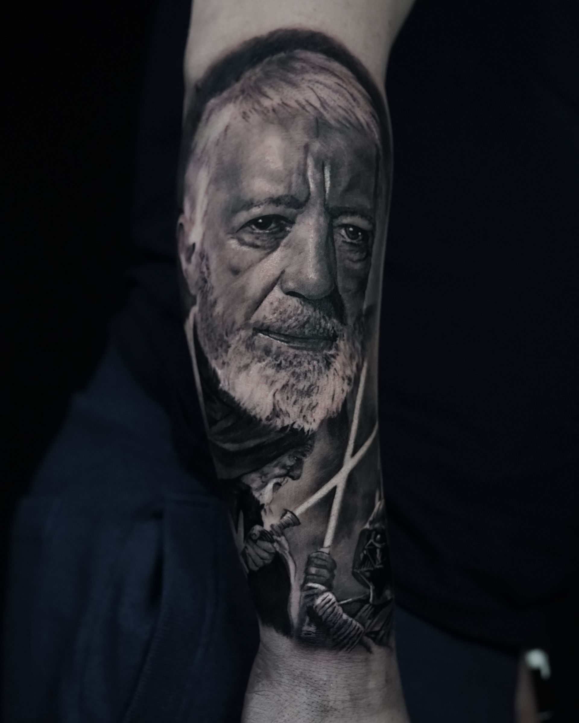 A black and white tattoo of a man with a beard on his arm.