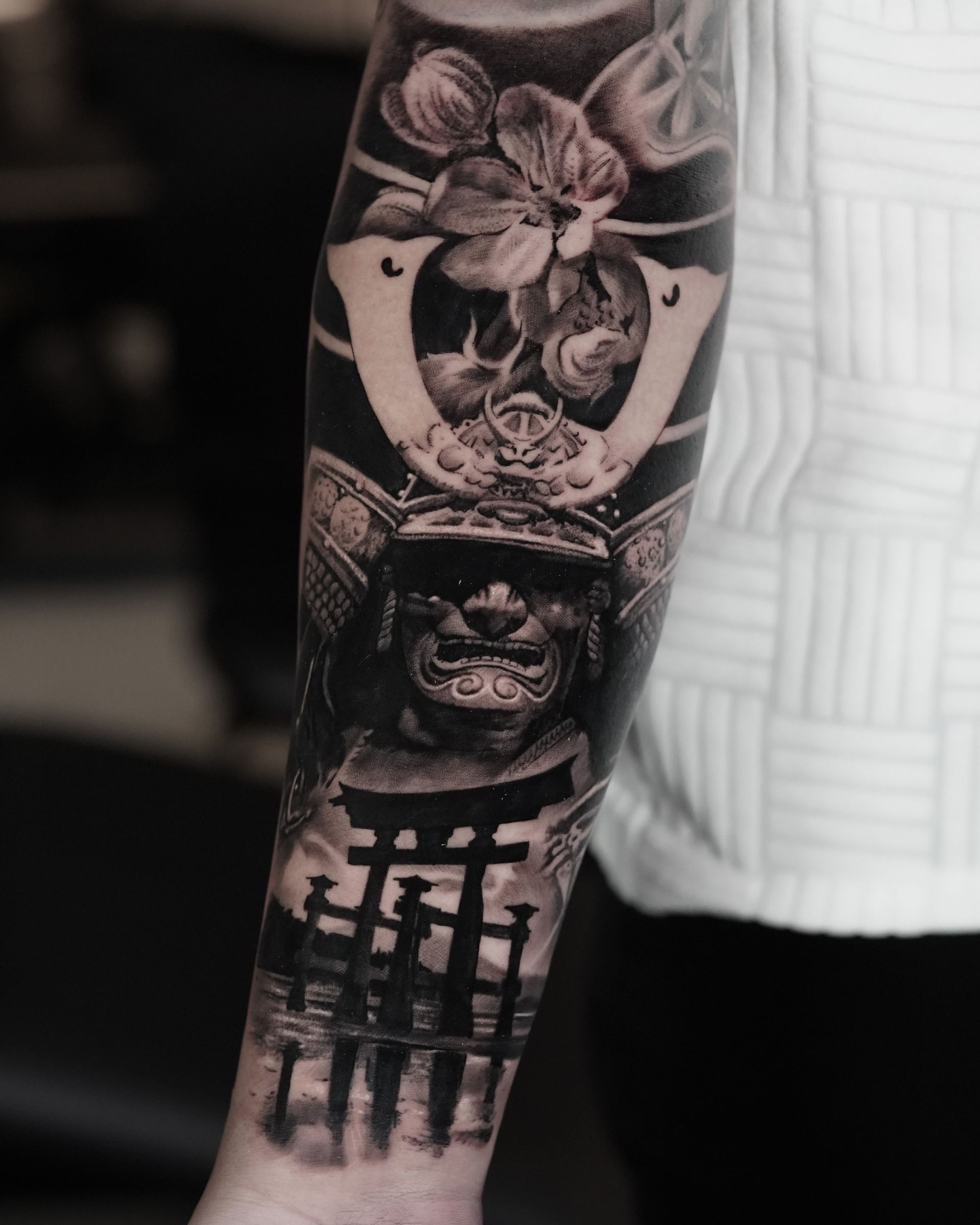 A man has a tattoo of a samurai on his forearm