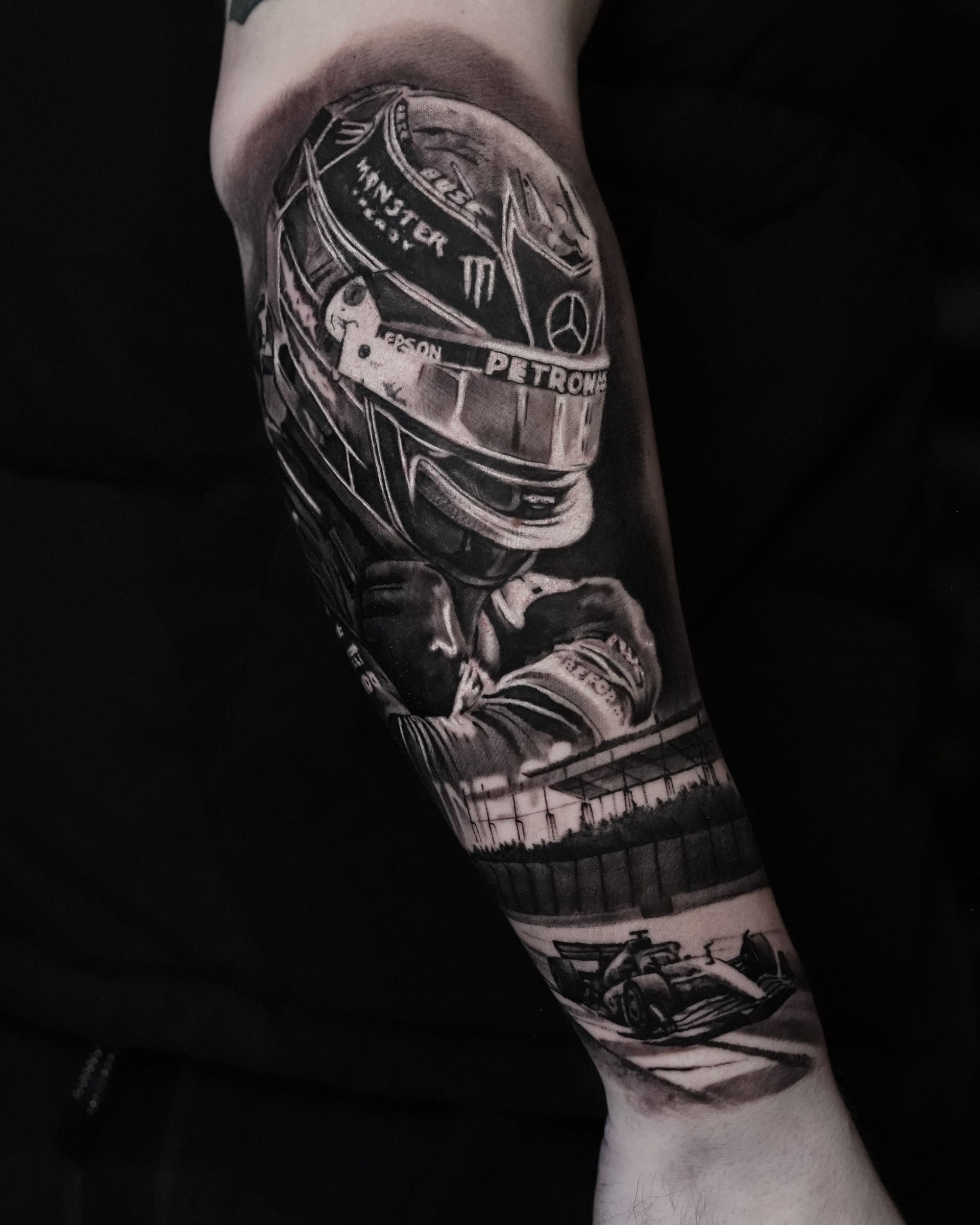 A black and white tattoo of a man wearing a helmet on his forearm.