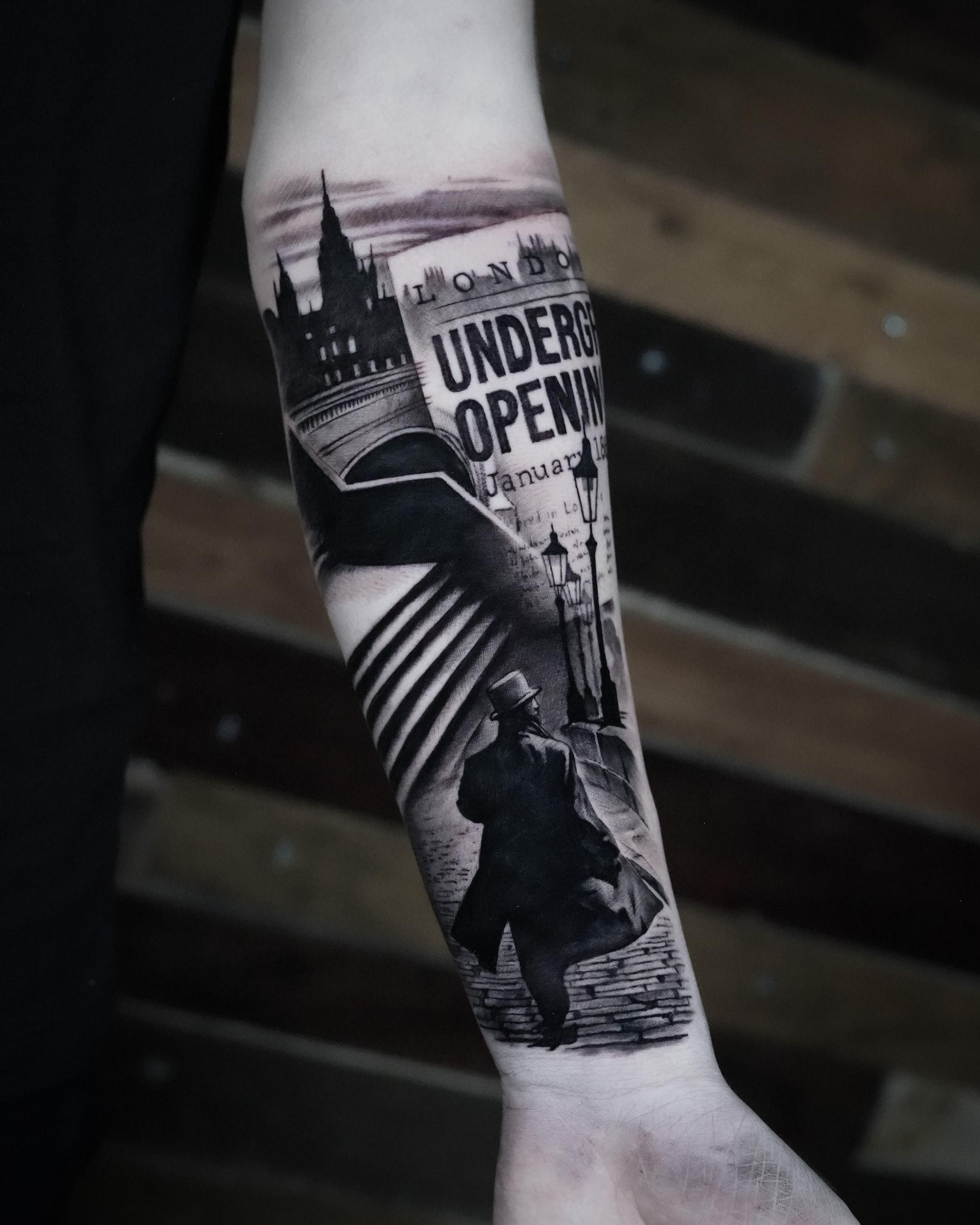A man has a tattoo on his forearm that says under open