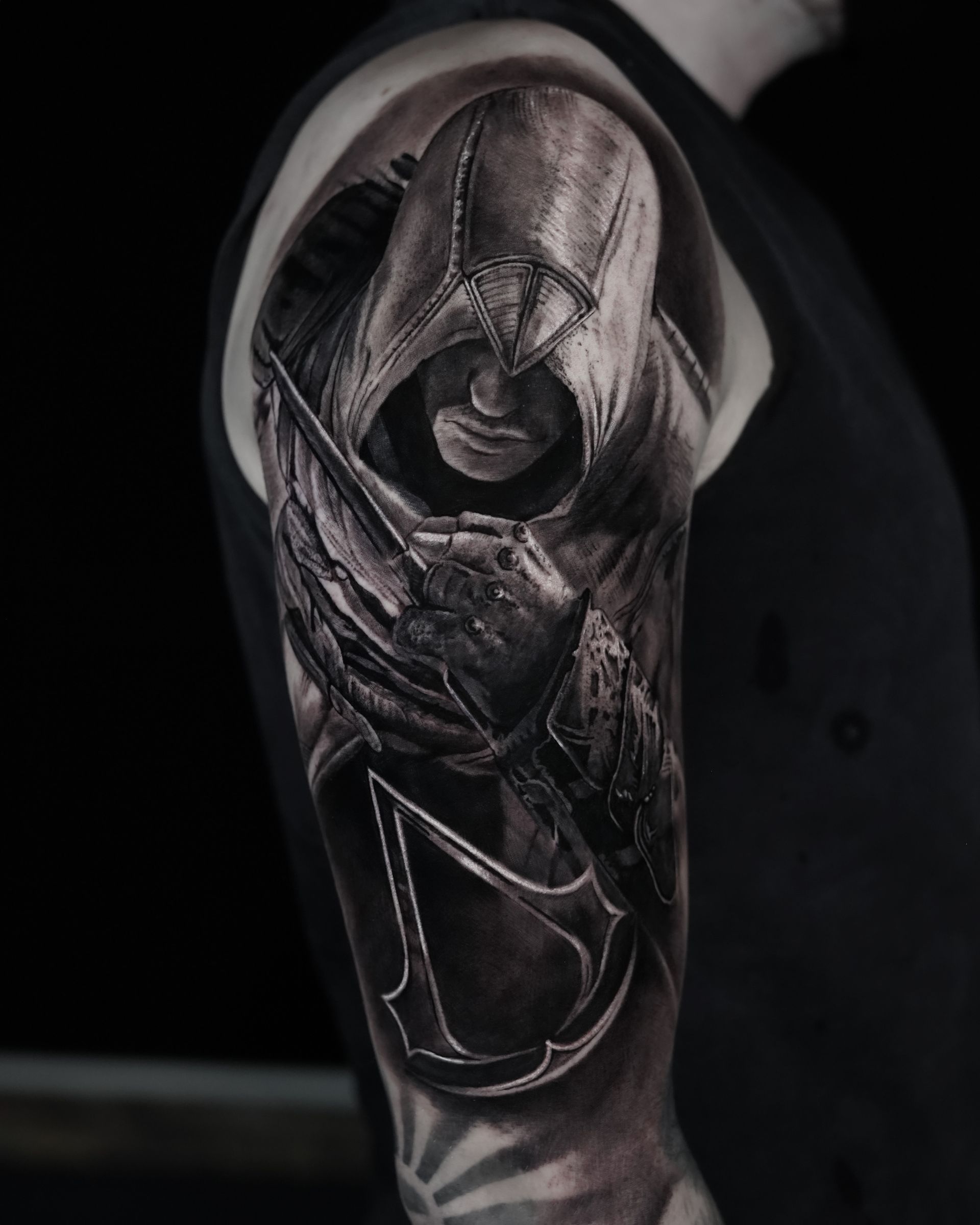 A man has a black and white tattoo of a man in a hood on his arm.