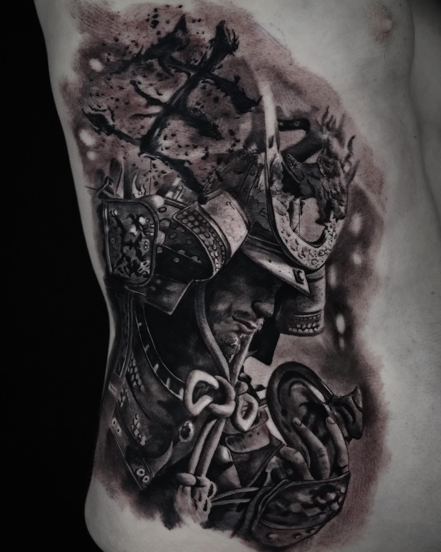 A black and white tattoo of a samurai on a man 's side.