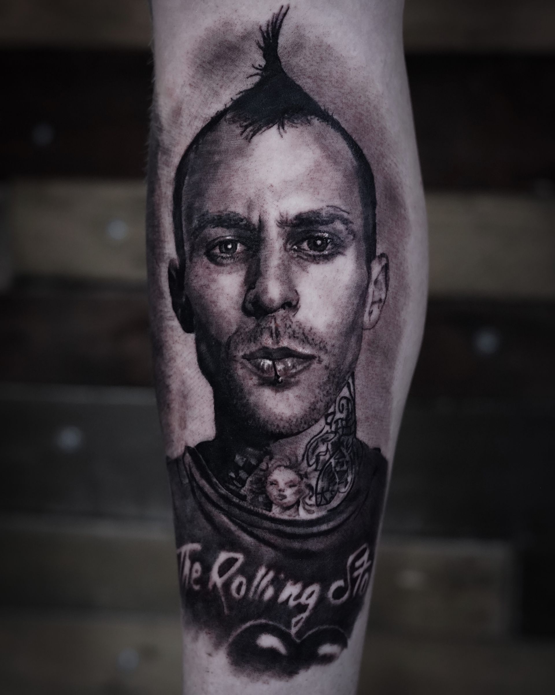 A black and white tattoo of a man with a mohawk on his head.