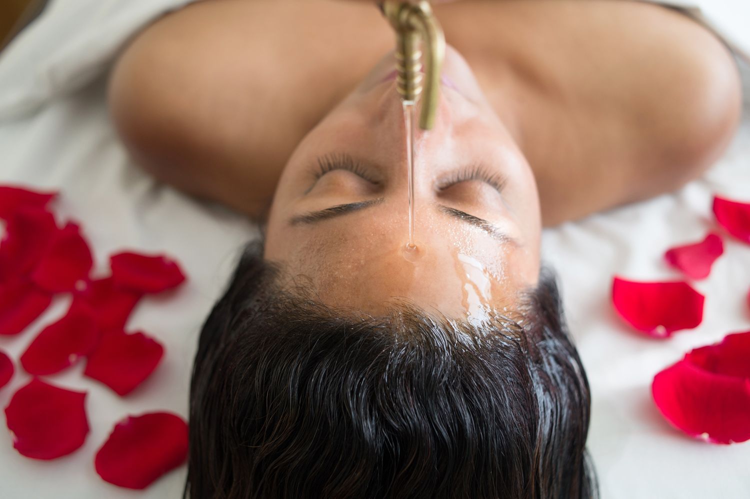 Massage therapist using wooden massage balls on a person’s back and neck