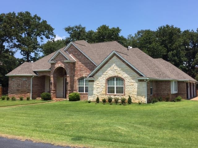 A large brick and stone house with a brown roof