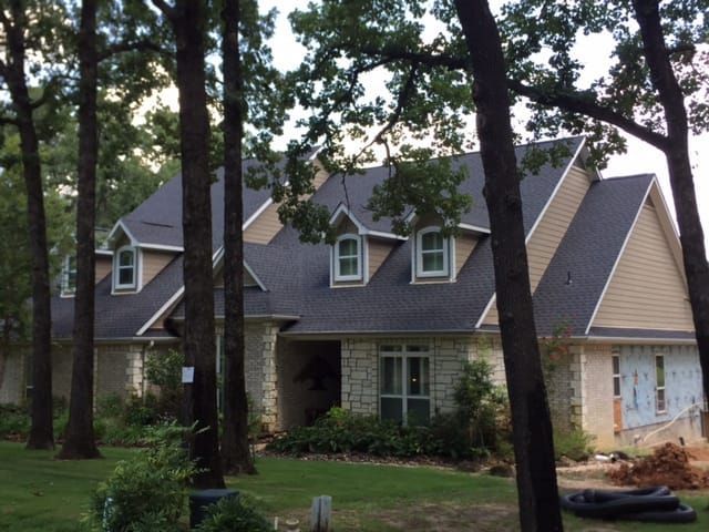 A large house is surrounded by trees and grass