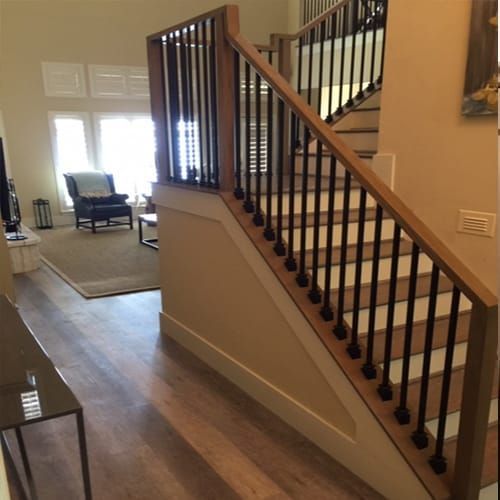 A wooden staircase with a metal railing in a living room