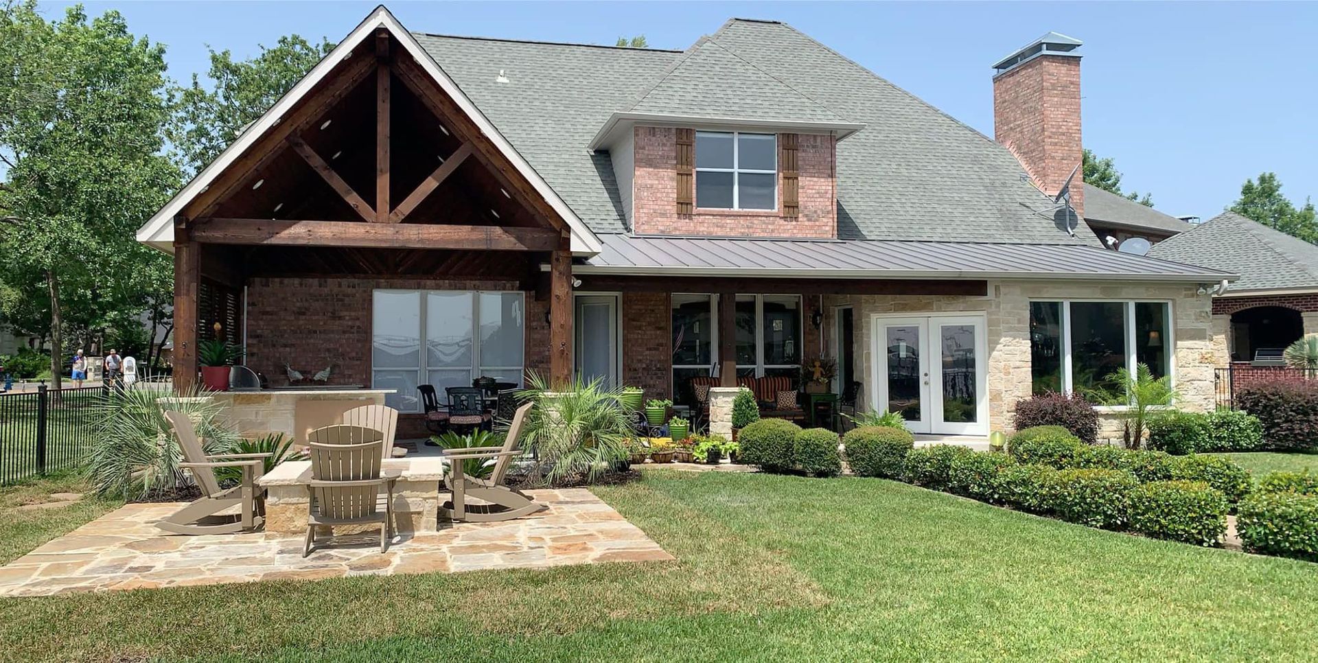 A large brick house with a large lawn in front of it.