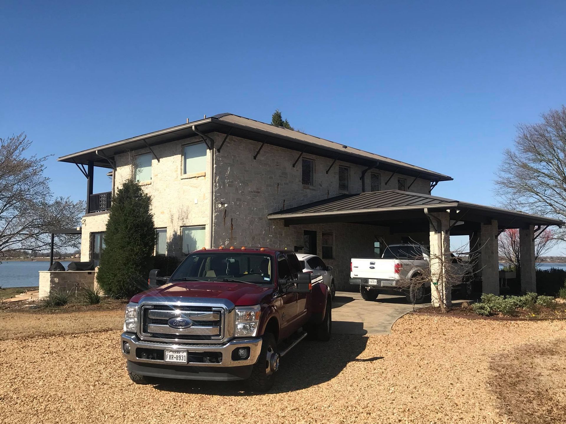 A red truck is parked in front of a large house