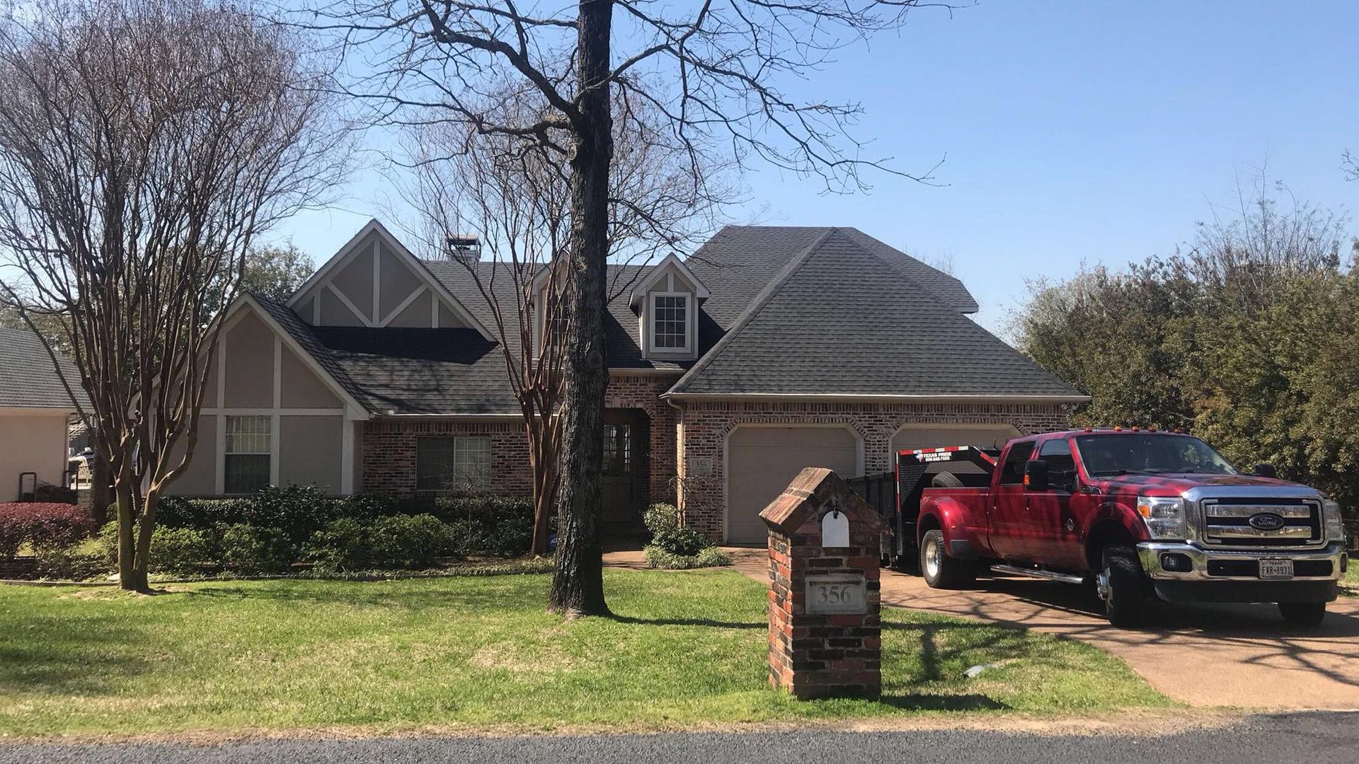 A red truck is parked in front of a house.