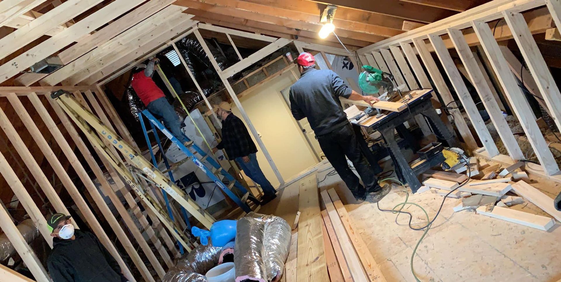 A group of people are working on a house under construction.