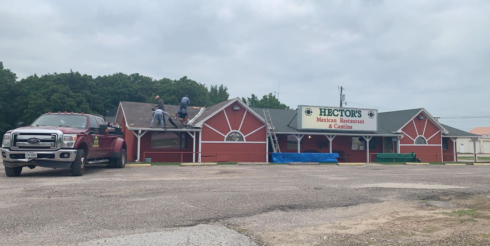 A truck is parked in front of a restaurant called hector 's