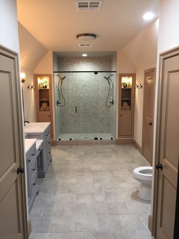 A bathroom with two sinks , a toilet and a walk in shower.