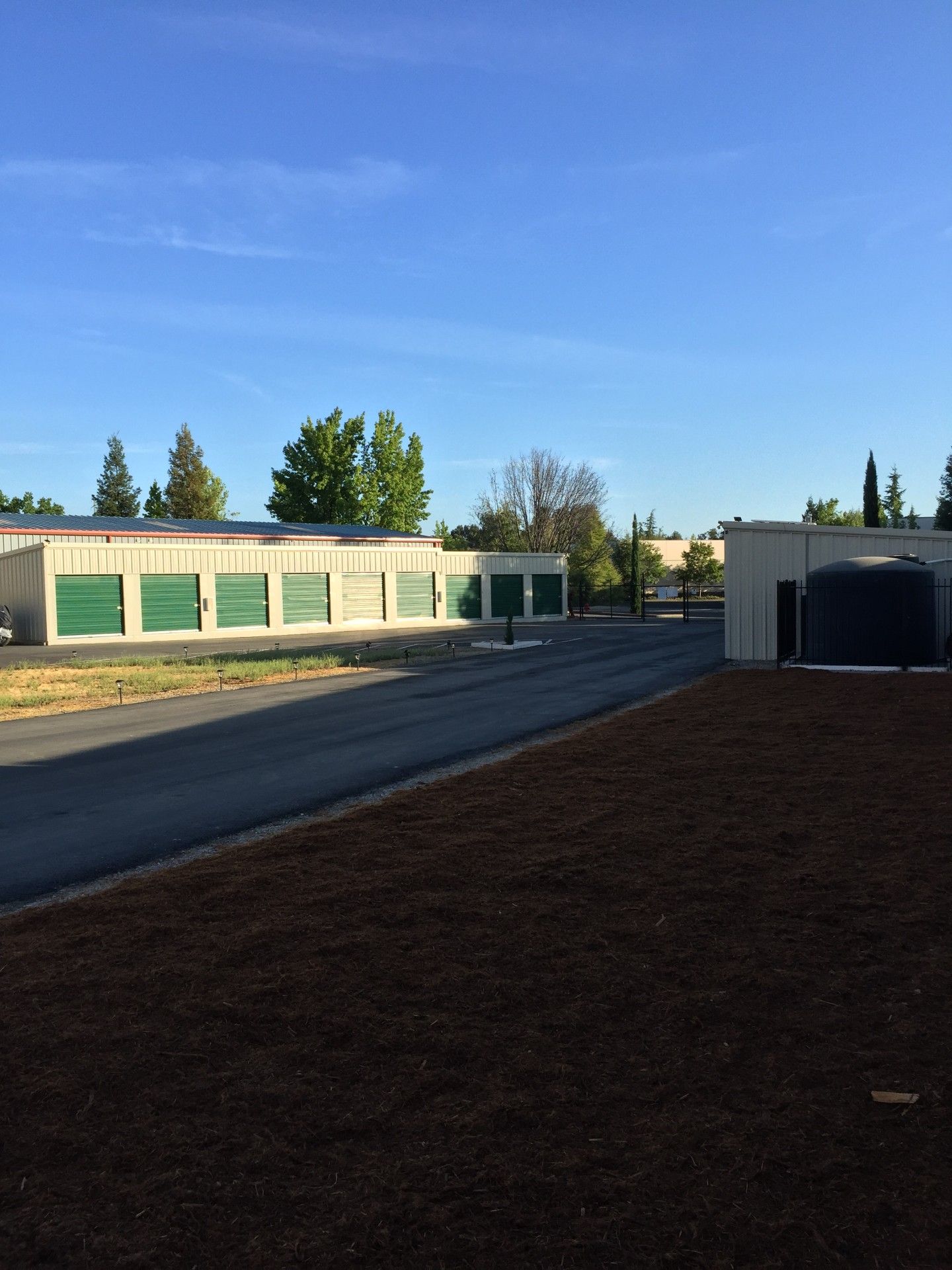 A row of buildings with green doors are next to a road