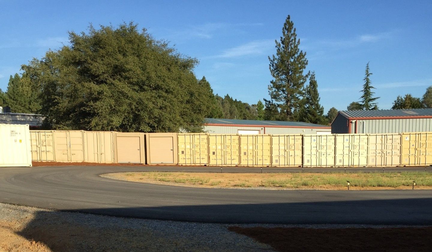 A row of wooden boxes are sitting on the side of a road.