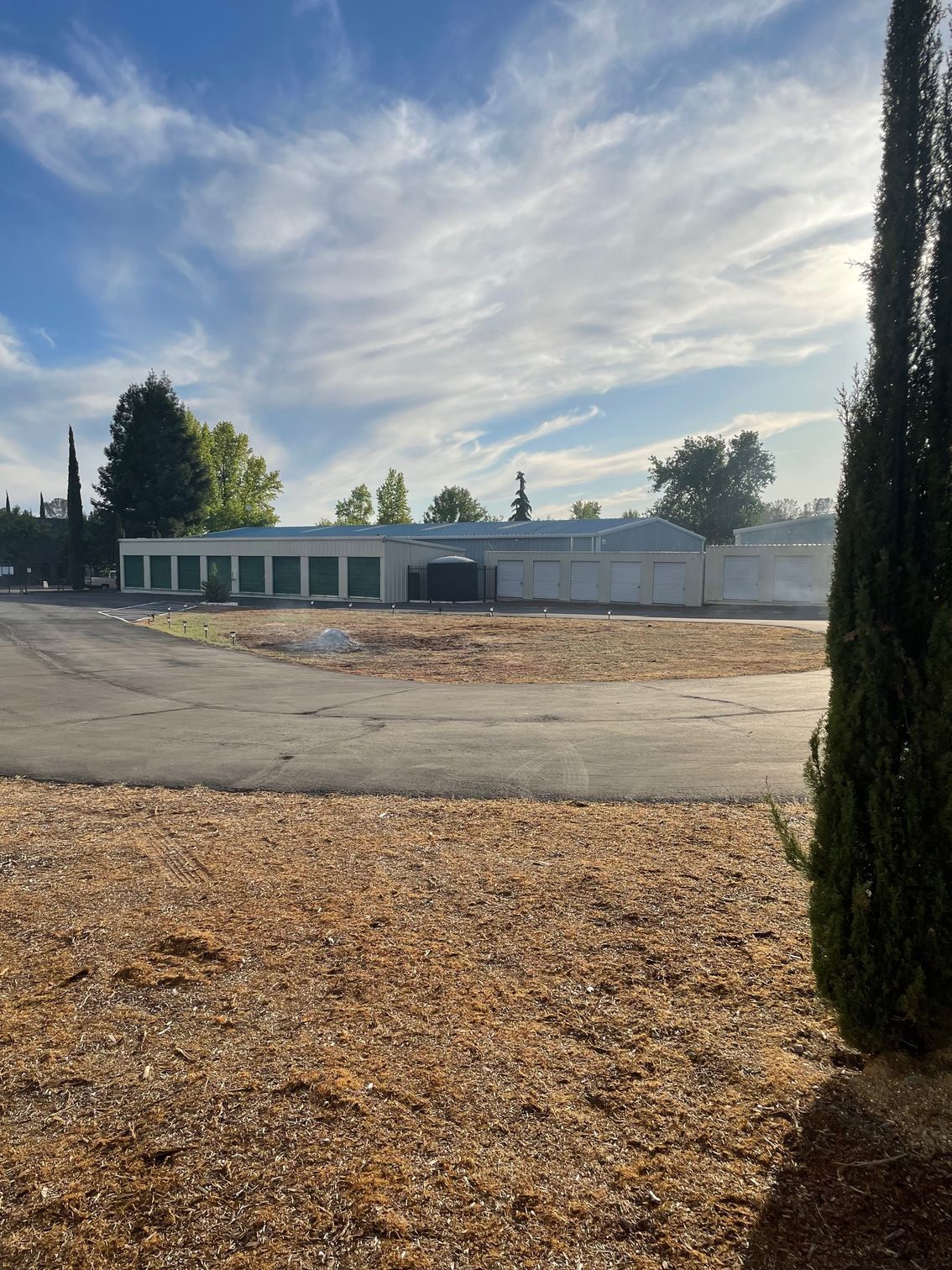A large white building is sitting in the middle of a dirt field.