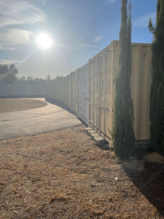 A row of storage containers are lined up next to each other in a parking lot.
