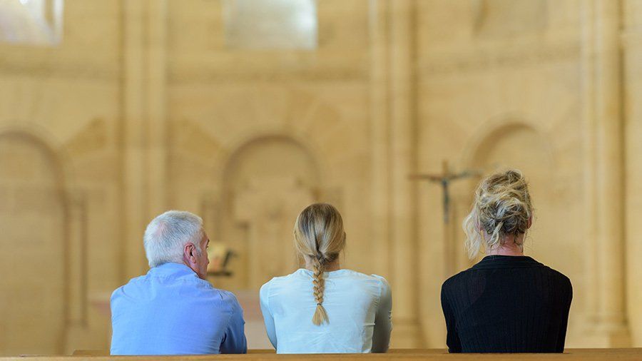 three people sitting in a church