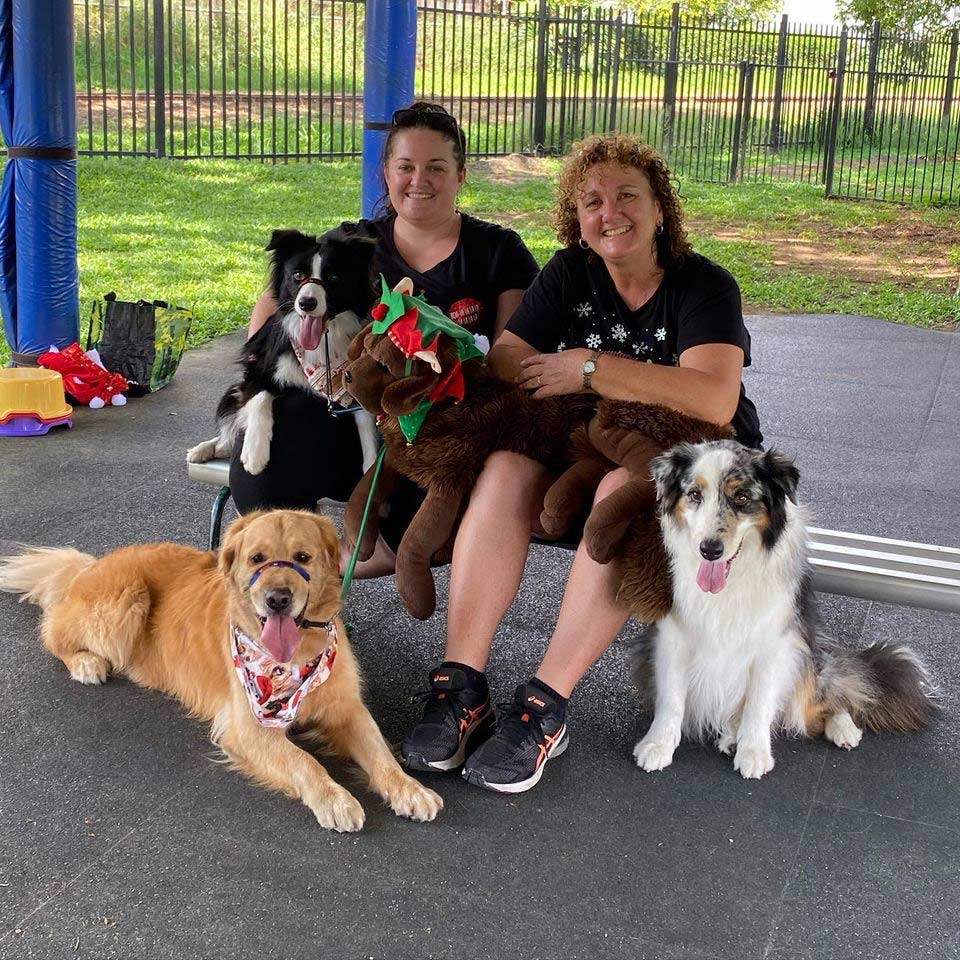 Two Trainers Smiling With Their Pets — Canine Training School In Cairns, QLD