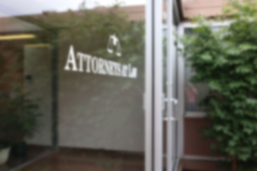 Photo of a window with scales of justice and the words 'attorneys at law' on the office building at 612 Kellogg Avenue in Ames, Iowa.