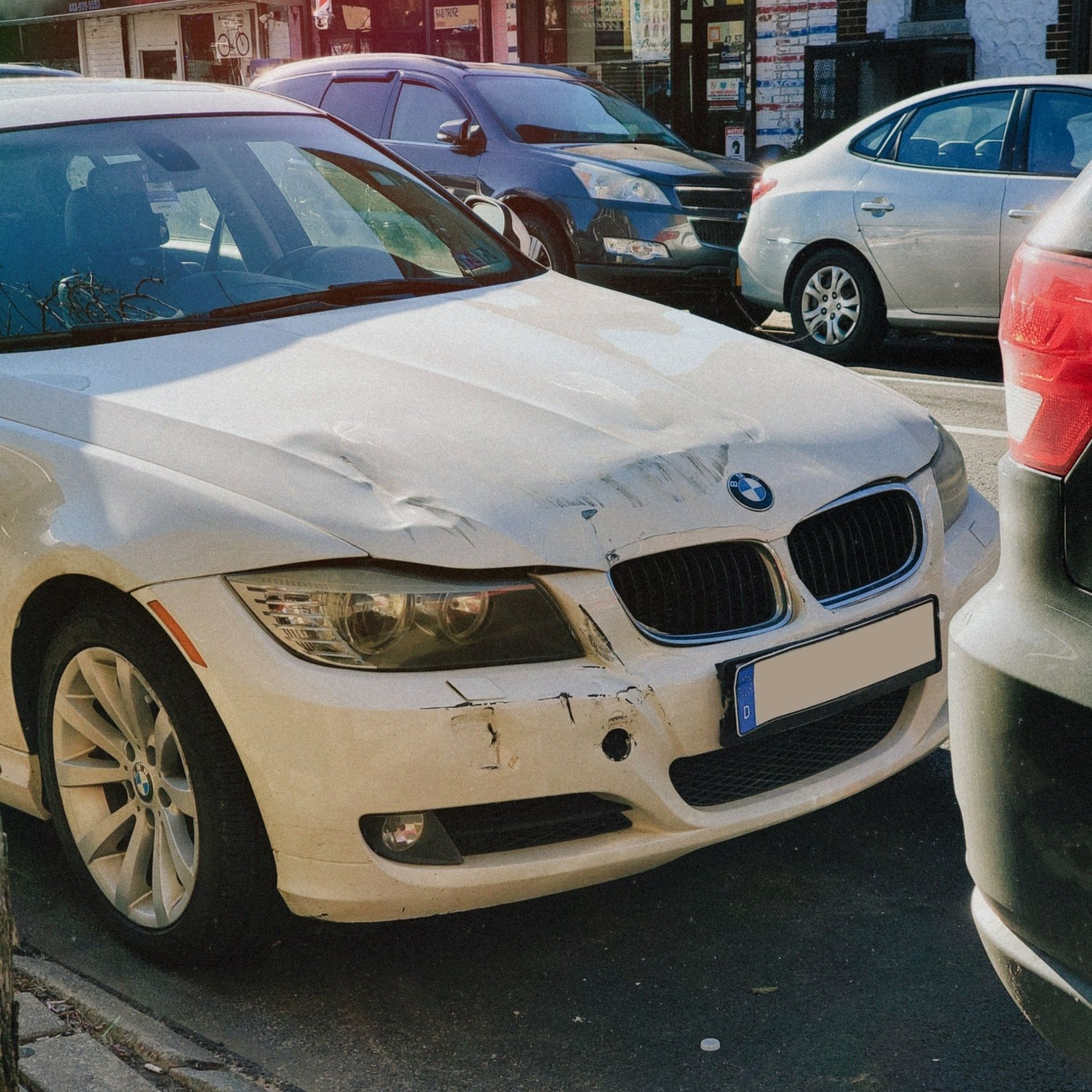 A white bmw is parked in a parking lot