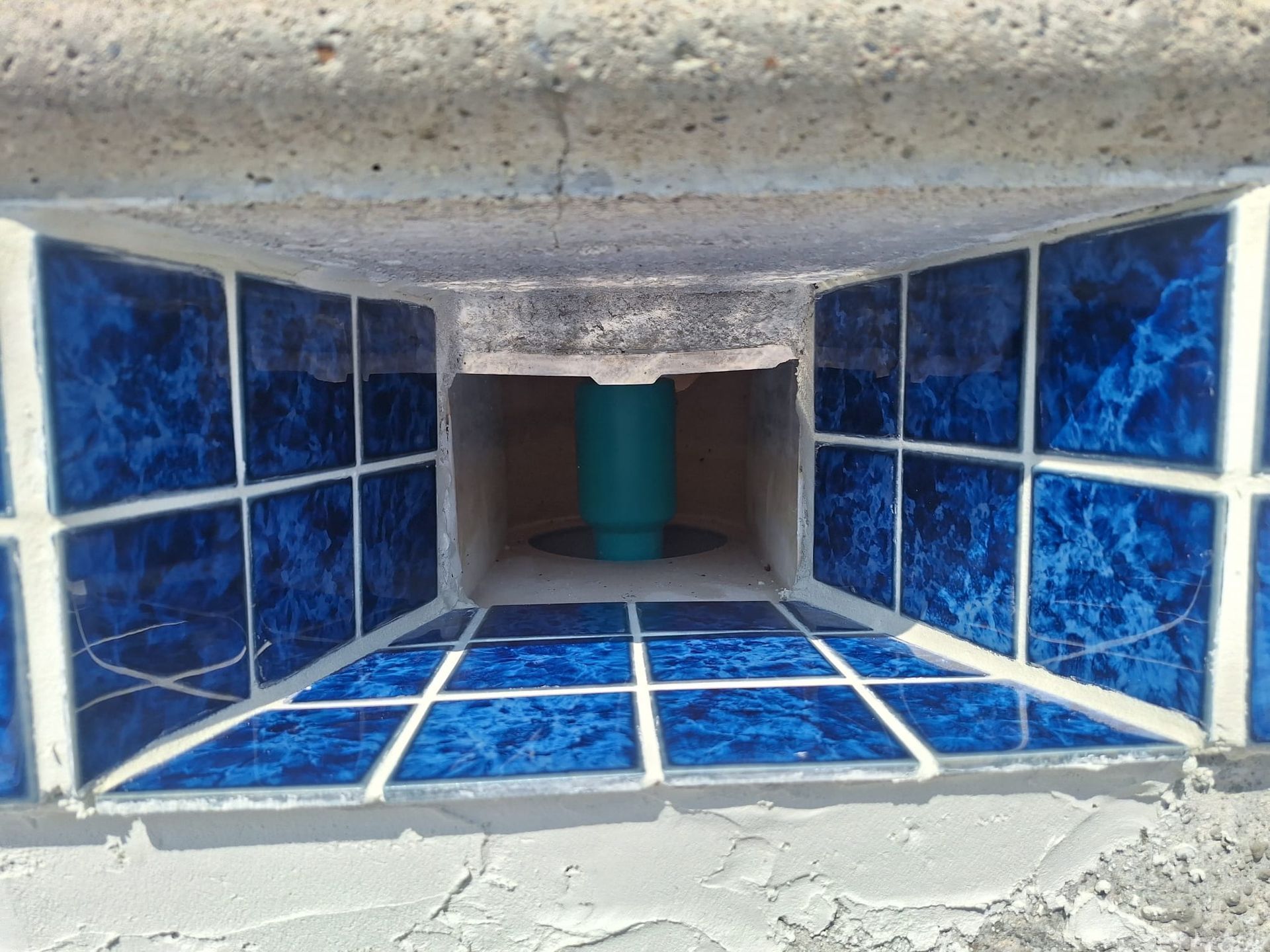 Blue tiles around showing a blue tube for pools used for the plumbing for pool restoration, repair